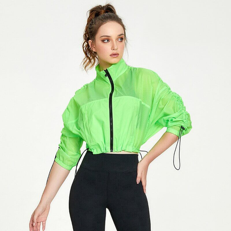 Woman wearing a bright green sports zipper jacket with drawstrings, ideal for yoga and fitness. Lightweight, breathable, and anti-wrinkle.